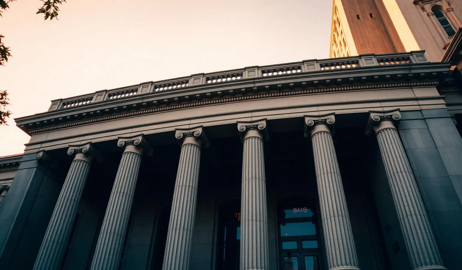 Fachada de prédio bancário com colunas no estilo neoclássico ao entardecer